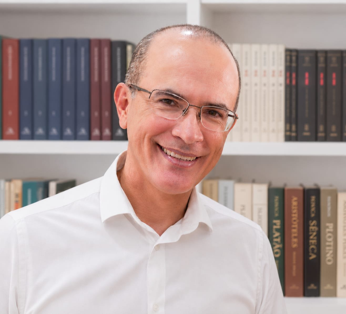 Rodrigo Oliveira diante de uma estante de livros